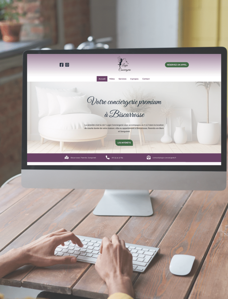 Vue de 2 mains devant un ordinateur posé sur une table en bois, ouvert sur la page d'accueil de Logis conciergerie