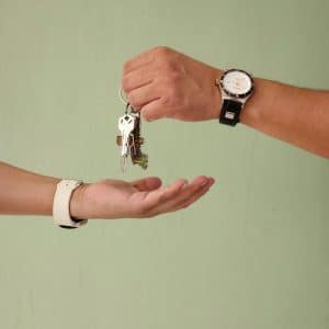 Vue de deux mains qui échangent un trousseau de clés